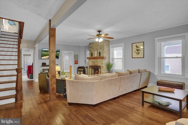 120 Hook St, Birdsboro, PA 19508 - living room with stairway, wood finished floors, a ceiling fan, a textured ceiling, and a stone fireplace