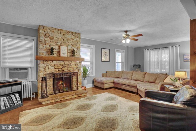 120 Hook St, Birdsboro, PA 19508 - living area featuring radiator heating unit, ceiling fan, a textured ceiling, cooling unit, and a fireplace