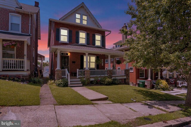 120 Hook St, Birdsboro, PA 19508 - view of front of house with a porch, a front lawn, and brick siding