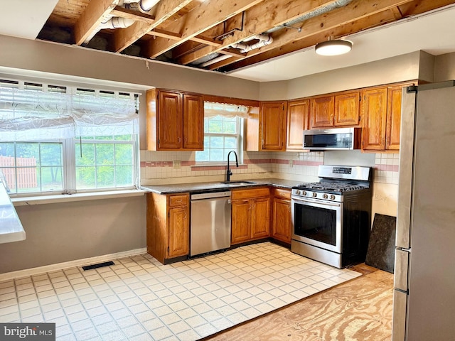 2575 Romig Rd, Gilbertsville, PA 19525 - kitchen featuring stainless steel appliances, brown cabinetry, and decorative backsplash