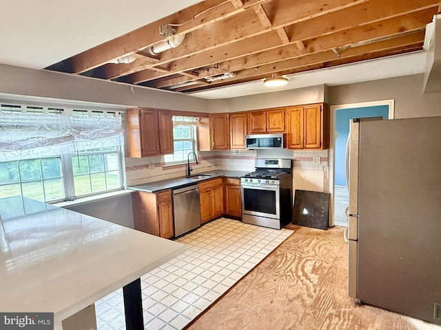 2575 Romig Rd, Gilbertsville, PA 19525 - kitchen with stainless steel appliances, brown cabinets, and tasteful backsplash