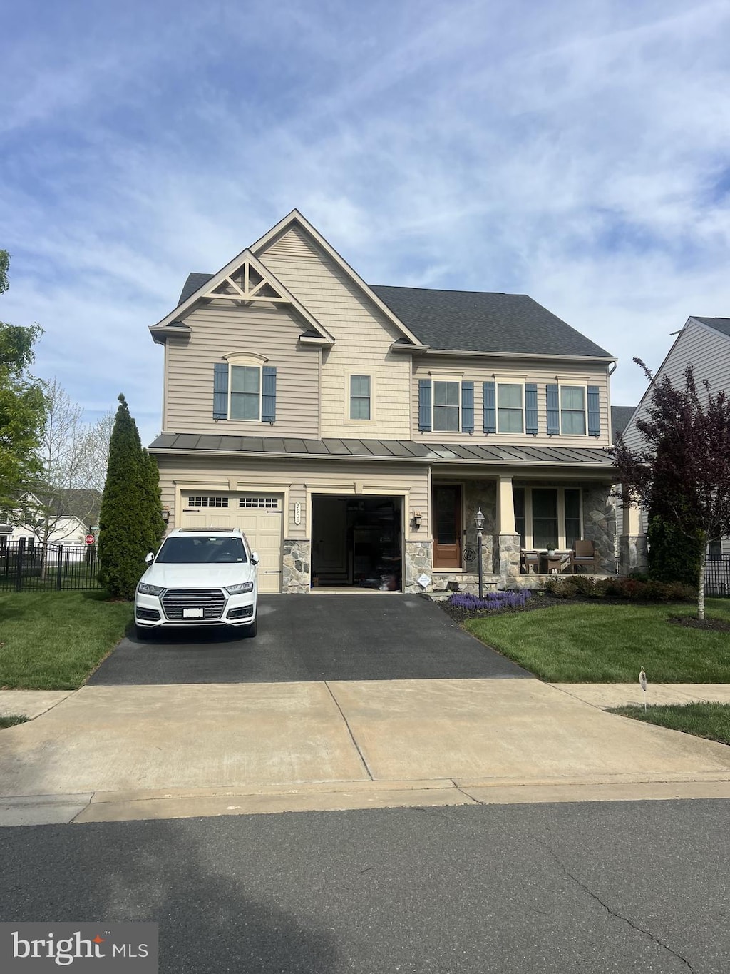 7901 Lukes Lodge Pl, Gainesville, VA 20155 - view of front of property featuring a standing seam roof, a garage, driveway, a metal roof, and a porch