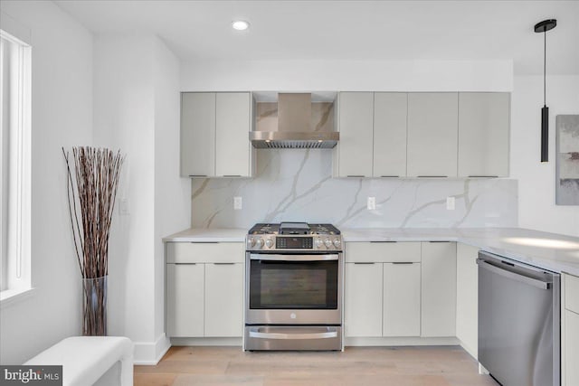 2618 E Hagert St, Philadelphia, PA 19125 - kitchen featuring stainless steel appliances, wall chimney exhaust hood, modern cabinets, tasteful backsplash, and light countertops
