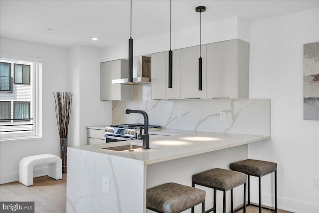 2618 E Hagert St, Philadelphia, PA 19125 - kitchen featuring wall chimney exhaust hood, backsplash, a kitchen breakfast bar, gray cabinets, and recessed lighting
