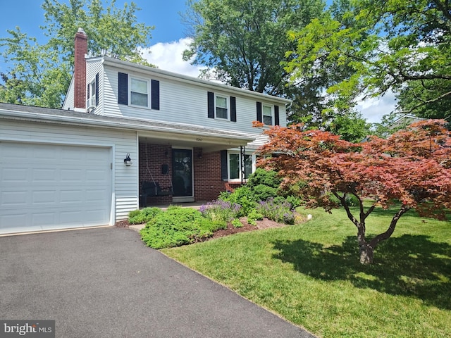 1047 Brookfield Cir, Quakertown, PA 18951 - traditional-style home with an attached garage, a chimney, a front lawn, brick siding, and asphalt driveway