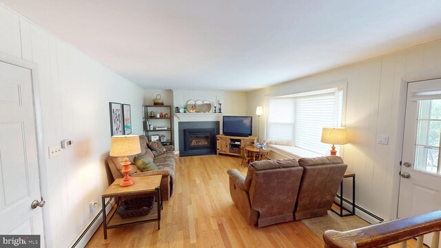 1047 Brookfield Cir, Quakertown, PA 18951 - living area with baseboard heating, light wood-style floors, and a glass covered fireplace
