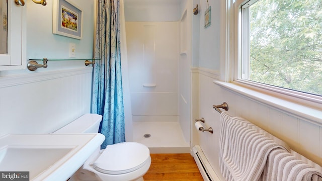 1047 Brookfield Cir, Quakertown, PA 18951 - bathroom featuring a shower with shower curtain, wainscoting, wood finished floors, and a baseboard heating unit