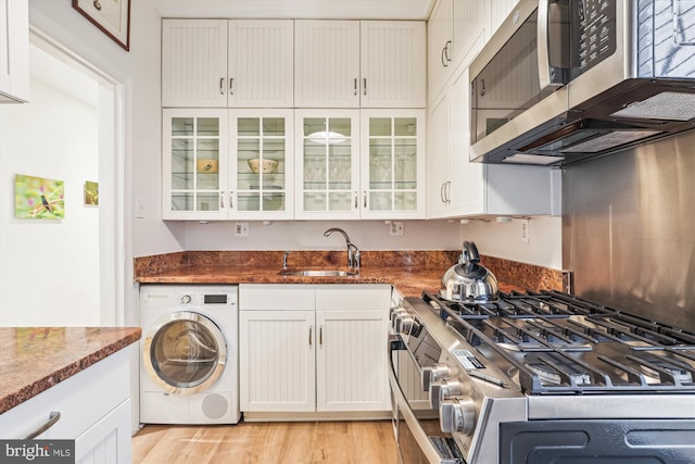 3042 R St NW Unit 2, Washington, DC 20007 - kitchen featuring washer / clothes dryer, stainless steel appliances, white cabinets, and dark stone countertops
