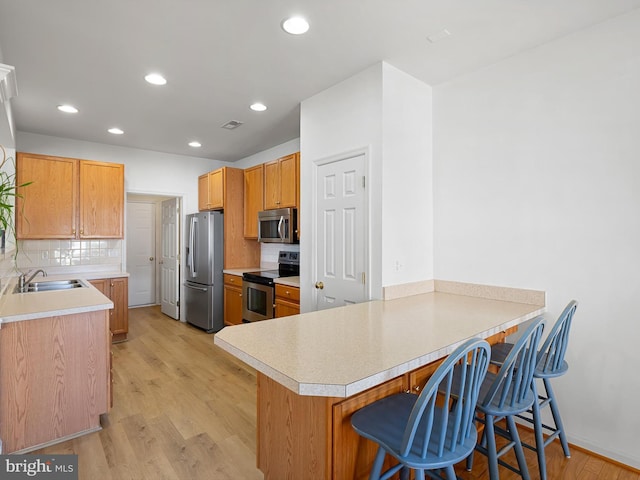 111 Sandridge Ct Unit 6-Jul, Millsboro, DE 19966 - kitchen featuring stainless steel appliances, a peninsula, backsplash, light wood-style floors, and recessed lighting