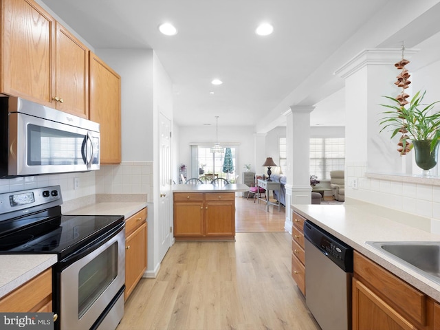 111 Sandridge Ct Unit 6-Jul, Millsboro, DE 19966 - kitchen with appliances with stainless steel finishes, light countertops, decorative backsplash, light wood-style flooring, and a peninsula