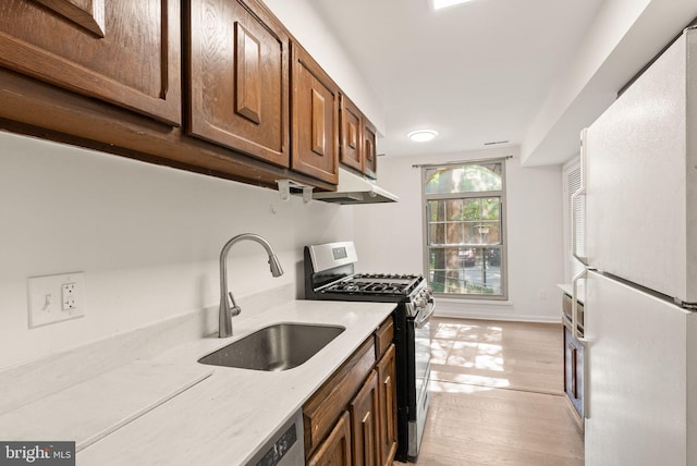 3378 Woodburn Rd Unit 11, Annandale, VA 22003 - kitchen with freestanding refrigerator, stainless steel gas stove, under cabinet range hood, and light wood-type flooring