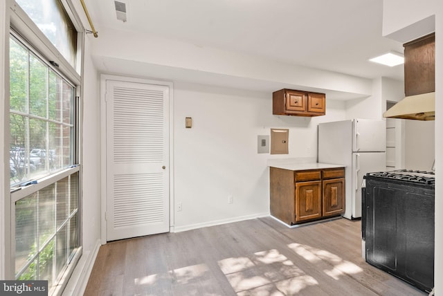 3378 Woodburn Rd Unit 11, Annandale, VA 22003 - kitchen featuring black gas range oven, brown cabinetry, light wood-type flooring, freestanding refrigerator, and light countertops