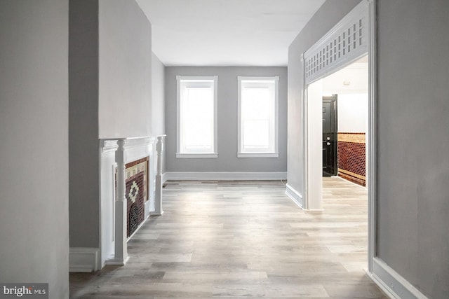 2332 N 25th St, Philadelphia, PA 19132 - unfurnished living room with light wood-style flooring and a tiled fireplace