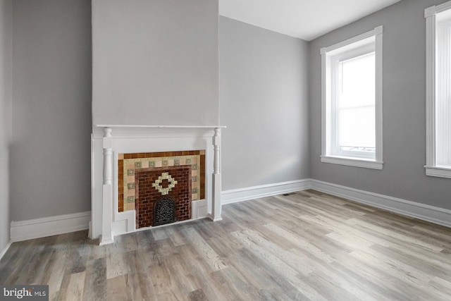 2332 N 25th St, Philadelphia, PA 19132 - unfurnished living room with wood finished floors and a tiled fireplace