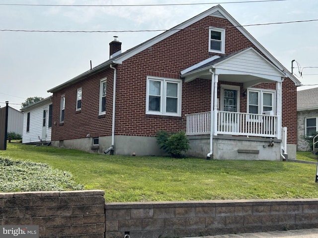 519 Jefferson St, East Greenville, PA 18041 - view of front facade featuring a porch, brick siding, a chimney, and a front lawn