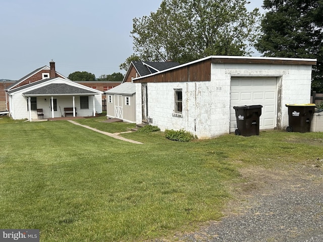 519 Jefferson St, East Greenville, PA 18041 - view of side of home featuring concrete block siding, a lawn, a garage, and covered porch