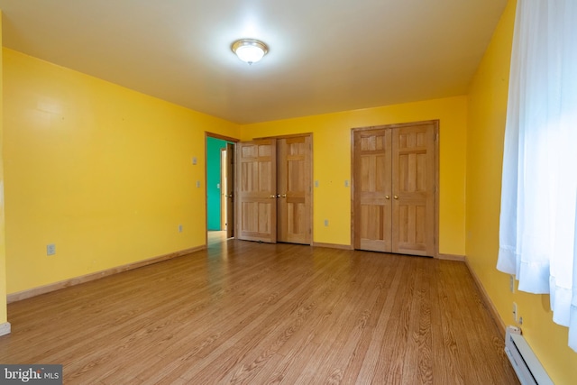 519 Jefferson St, East Greenville, PA 18041 - unfurnished bedroom with a baseboard radiator, multiple closets, and light wood finished floors
