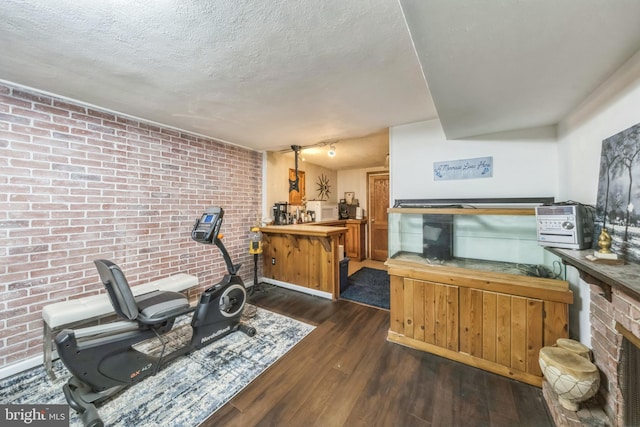 712 Chesapeake St SE, Washington, DC 20032 - living area featuring hardwood / wood-style flooring, brick wall, and a textured ceiling