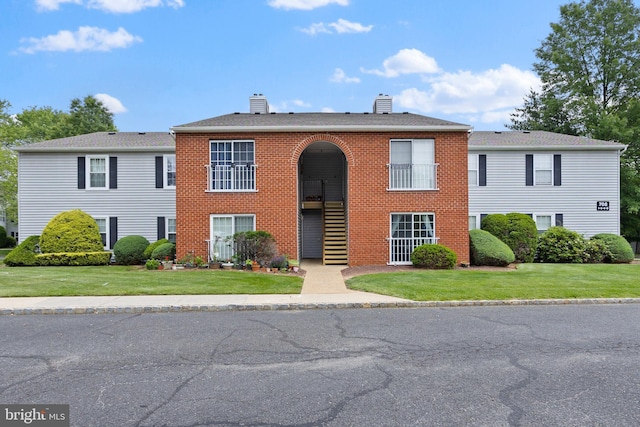 708 Zlotkin Cir, Freehold, NJ 07728 - view of front of home featuring a chimney, a front yard, and brick siding