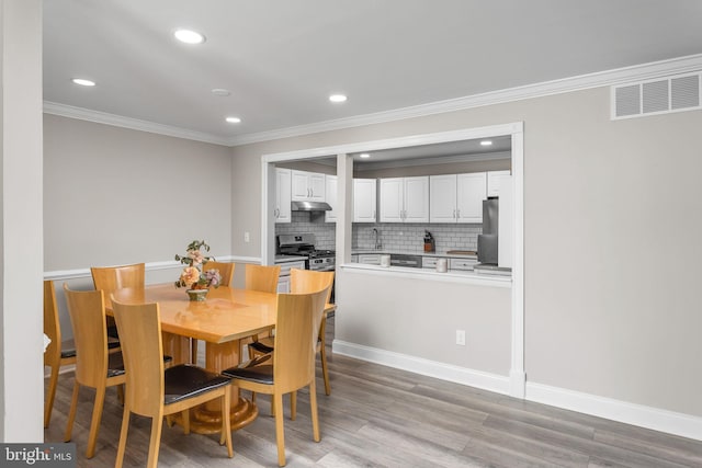 708 Zlotkin Cir, Freehold, NJ 07728 - dining space with crown molding, recessed lighting, and light wood-style floors