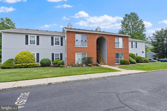 708 Zlotkin Cir, Freehold, NJ 07728 - view of front of home with a chimney, a front lawn, stairway, and brick siding