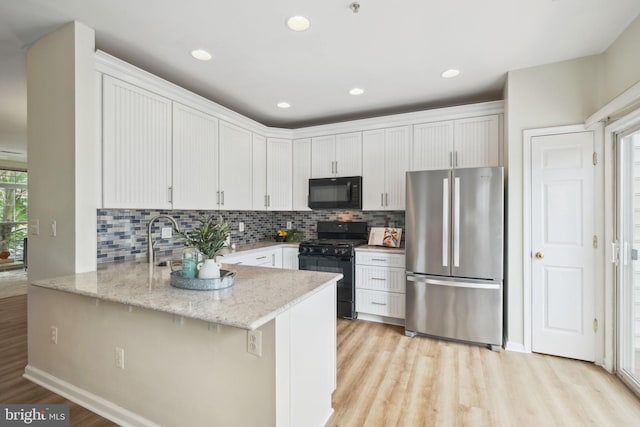 622 Main St Unit 622B, Gaithersburg, MD 20878 - kitchen featuring black appliances, light wood-type flooring, backsplash, white cabinets, and a peninsula