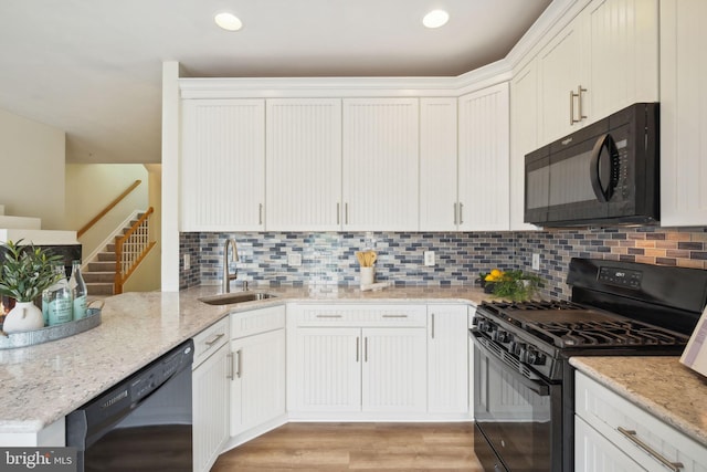 622 Main St Unit 622B, Gaithersburg, MD 20878 - kitchen with black appliances, tasteful backsplash, light stone countertops, light wood-type flooring, and white cabinets