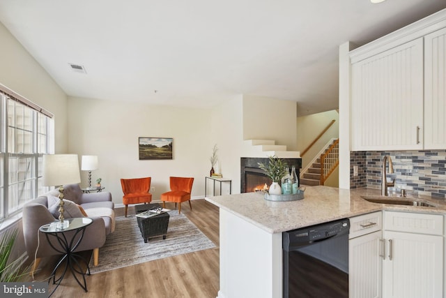 622 Main St Unit 622B, Gaithersburg, MD 20878 - kitchen with black dishwasher, open floor plan, tasteful backsplash, a fireplace, and light wood-style floors