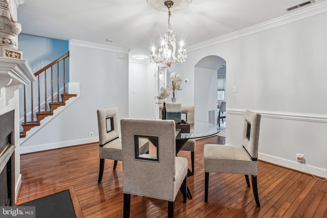 3818 White Post Ct, Alexandria, VA 22304 - dining room with crown molding, a chandelier, arched walkways, wood-type flooring, and stairway