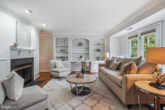 3818 White Post Ct, Alexandria, VA 22304 - living room featuring wood finished floors, crown molding, a fireplace with flush hearth, built in shelves, and recessed lighting