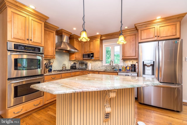 760 Audubon Dr, North Wales, PA 19454 - kitchen with stainless steel appliances, wall chimney range hood, light wood-style flooring, light stone countertops, and backsplash