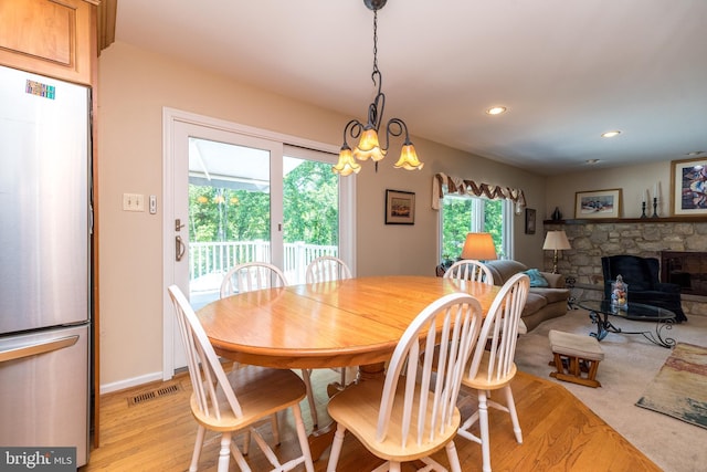 760 Audubon Dr, North Wales, PA 19454 - dining space featuring a fireplace, light wood-style floors, recessed lighting, and a chandelier