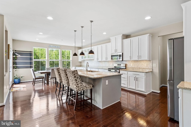29 Carrington Way, Marlton, NJ 08053 - kitchen featuring appliances with stainless steel finishes, white cabinets, decorative backsplash, dark wood-style flooring, and a center island with sink