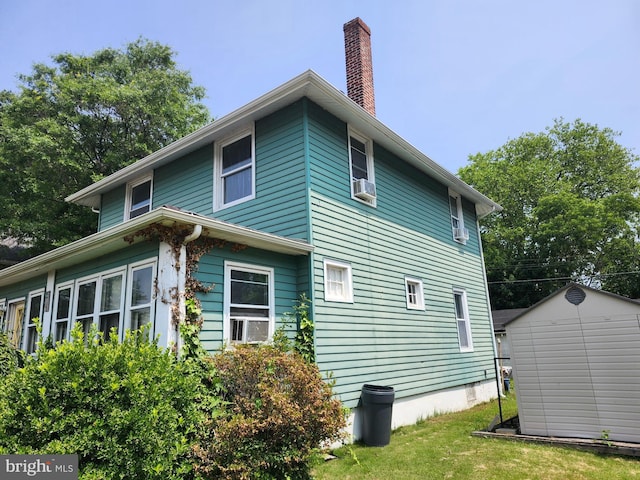 15 Spring St, Penns Grove, NJ 08069 - view of side of home with a shed, a chimney, cooling unit, and a lawn