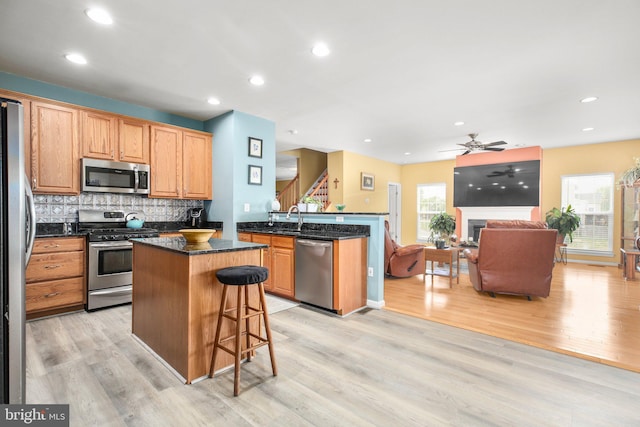 1 Fletcher Dr, Fredericksburg, VA 22406 - kitchen featuring stainless steel appliances, light wood-style flooring, a center island, a ceiling fan, and decorative backsplash