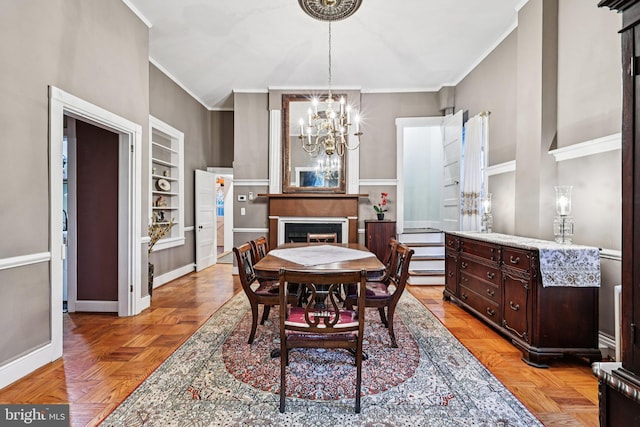 12353 Barbee Rd, Bristow, VA 20136 - dining area with crown molding, a chandelier, built in features, and a fireplace