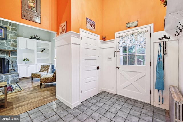 12353 Barbee Rd, Bristow, VA 20136 - tiled foyer entrance featuring a high ceiling, radiator heating unit, and a stone fireplace