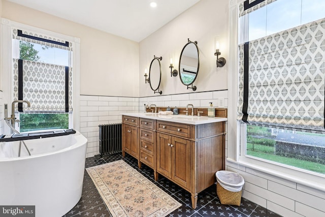 12353 Barbee Rd, Bristow, VA 20136 - bathroom featuring tile walls, radiator heating unit, healthy amount of natural light, a wainscoted wall, and recessed lighting