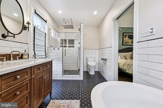 12353 Barbee Rd, Bristow, VA 20136 - ensuite bathroom featuring tile walls, a stall shower, vanity, wainscoting, and recessed lighting