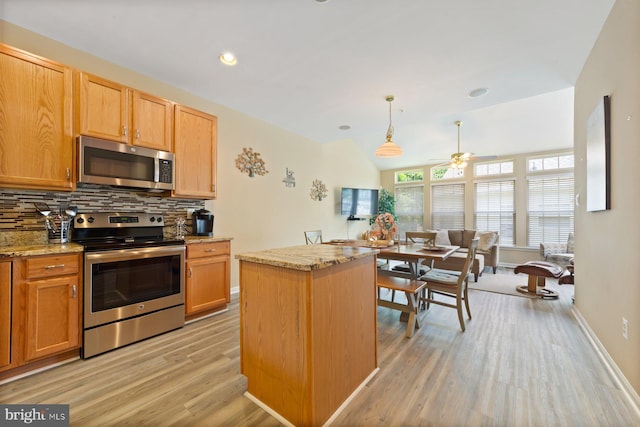 10112 Collington Campus Dr Unit 7, Bowie, MD 20721 - kitchen featuring appliances with stainless steel finishes, decorative backsplash, light wood-type flooring, ceiling fan, and a kitchen island