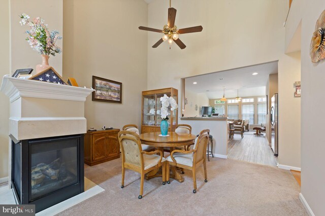 10112 Collington Campus Dr Unit 7, Bowie, MD 20721 - dining area featuring light colored carpet, ceiling fan, a multi sided fireplace, a high ceiling, and recessed lighting