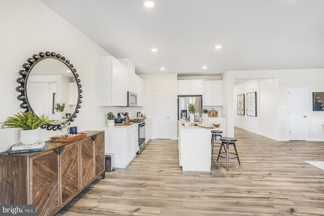 20 Hidden Brook Blvd, Dover, DE 19904 - kitchen featuring appliances with stainless steel finishes, light wood finished floors, light countertops, an island with sink, and recessed lighting