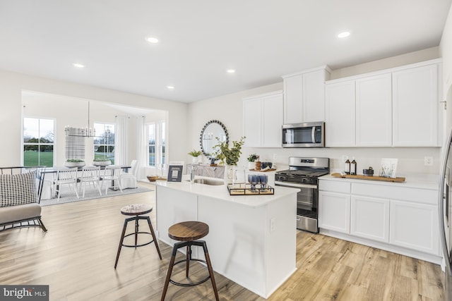 20 Hidden Brook Blvd, Dover, DE 19904 - kitchen with stainless steel appliances, a breakfast bar area, light wood finished floors, white cabinets, and recessed lighting