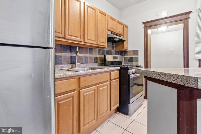 2904 N Taney St, Philadelphia, PA 19132 - kitchen with appliances with stainless steel finishes, under cabinet range hood, decorative backsplash, light tile patterned floors, and light countertops