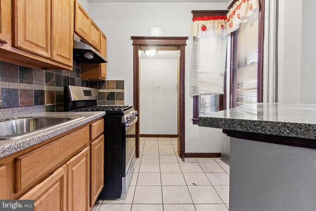 2904 N Taney St, Philadelphia, PA 19132 - kitchen with stainless steel range with gas cooktop, under cabinet range hood, backsplash, and light tile patterned floors