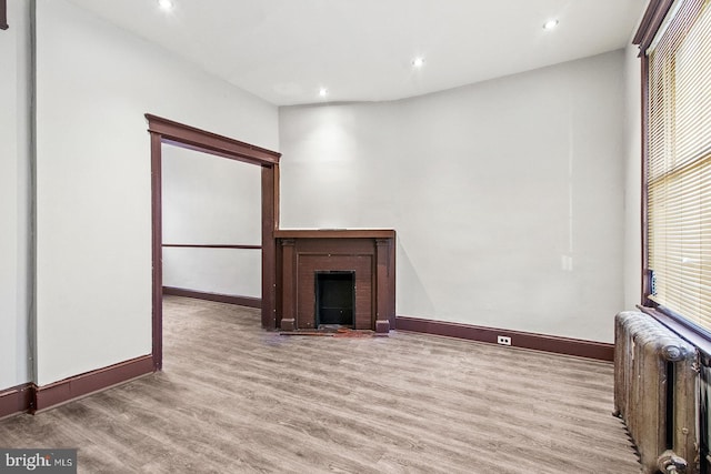 2904 N Taney St, Philadelphia, PA 19132 - unfurnished living room with radiator heating unit, wood finished floors, a fireplace with flush hearth, and recessed lighting