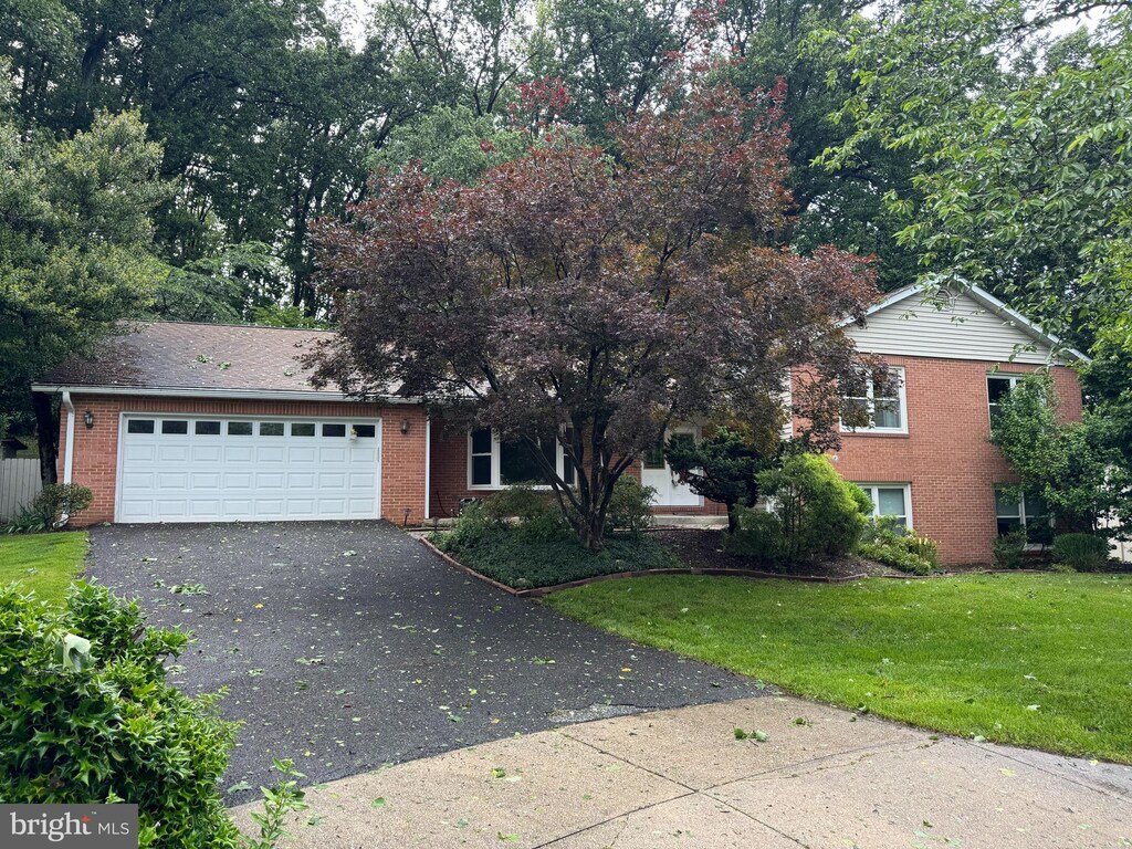 6102 Gallery St, Bowie, MD 20720 - view of front facade featuring asphalt driveway, brick siding, a garage, and a front lawn
