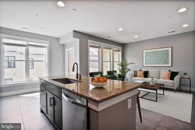 1220 Main Line Blvd Unit 102, Alexandria, VA 22301 - kitchen with stainless steel dishwasher, recessed lighting, a kitchen island with sink, light tile patterned flooring, and dark stone counters