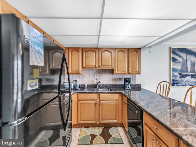 107 Convention Center Dr Unit 1410D, Ocean City, MD 21842 - kitchen with black appliances, tasteful backsplash, dark stone counters, light tile patterned floors, and brown cabinetry