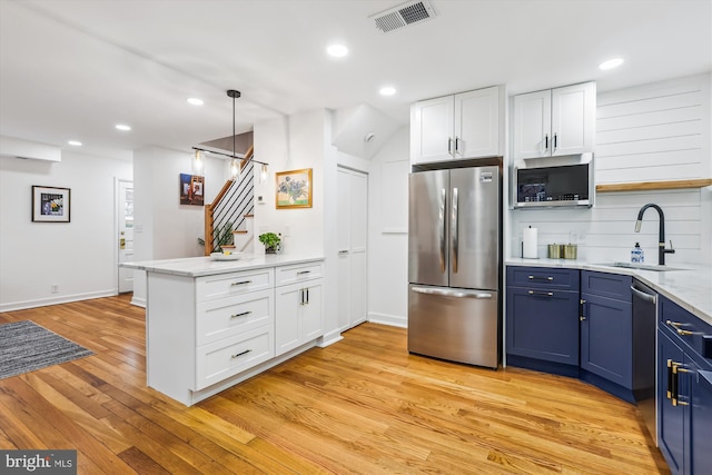 2806 S Abingdon St Unit A, Arlington, VA 22206 - kitchen with appliances with stainless steel finishes, blue cabinets, a peninsula, light wood-type flooring, and white cabinetry